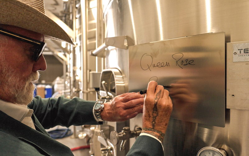 Roger Taylor autografando um tanque de vinho - Queen Côtes de Provence Rosé